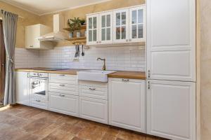 a kitchen with white cabinets and a sink at Holiday house DIVNA in Pinezici