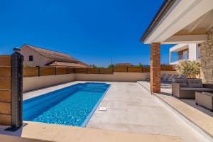 a swimming pool in the backyard of a house at Holiday house DIVNA in Pinezici