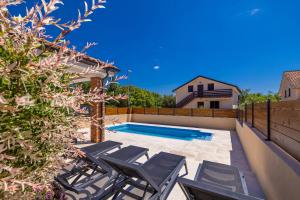 a patio with chairs and a swimming pool at Holiday house DIVNA in Pinezici +23 photos