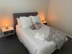 a bed with two towels and two candles on it at A Prince on Clinton in Orange