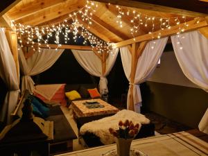 a room with a canopy with lights and a couch at Domek w lesie in Łopuszno