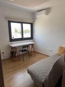 Un dormitorio con un escritorio y una cama y una ventana. en Stylish 2 bedroom apartment in Limassol, en Limassol 4 fotos más