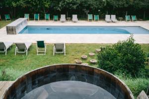 a pool with chairs and a table and a swimming pool at Country Lodge in Les Épasses