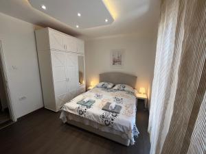a bedroom with a bed and a white cabinet at Rakovica Centar in Belgrade