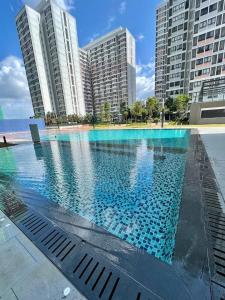 a large swimming pool in front of tall buildings at The Ruby R HorizonSuites KLIA WIFI in Kampung Dengkil