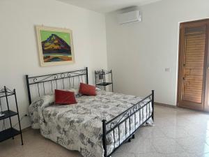 a bedroom with a bed with two red pillows on it at Lotelito Villa in Calvanico