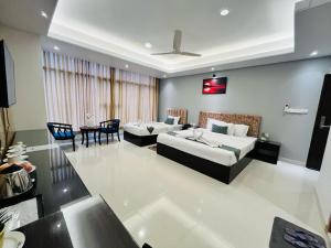 a large living room with two beds and a table at Sylhet Paradise Inn in Sylhet +130 photos