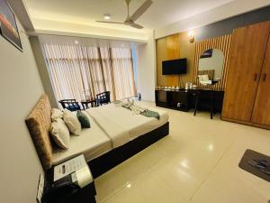 a bedroom with a bed and a desk and a television at Sylhet Paradise Inn in Sylhet