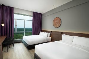 Rúm í herbergi á Quest Hotel Midport Port Dickson