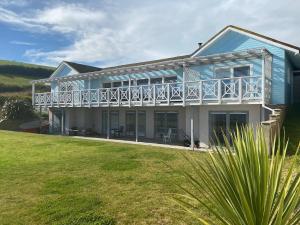 una casa blu con un balcone e un prato di The Sandcastle. Private steps onto a sandy beach a Pembrokeshire