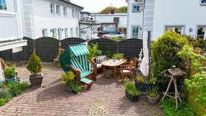 een terras met een tafel, stoelen en planten bij Haus Mozart Fewo mit Balkon in Binz +1 foto