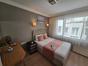 Un dormitorio con una cama y una mesa y una ventana. en TAKSİM LİFE HOUSE, en Estambul