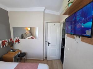 Un dormitorio con una cama y un televisor de pantalla plana. en TAKSİM LİFE HOUSE, en Estambul 38 fotos más