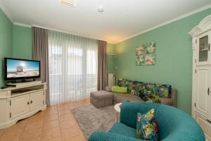 een woonkamer met een bank en een tv bij Haus Mozart Fewo mit Balkon in Binz