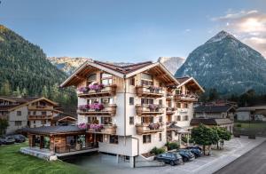 un hotel in montagna con auto parcheggiate in un parcheggio di Sonnenhof Genusshotel & Appartements a Pertisau