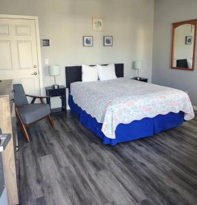 a bedroom with a large bed and a chair at Pacific Plaza #603 - Salty Studio - StudioD-Q in Oceano