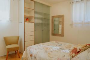 a bedroom with a bed and a chair and a mirror at Lake House in Nago-Torbole