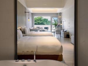 two beds in a hotel room with a mirror at Hotel dua Kenting in Kenting