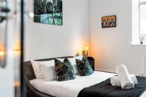 ein Schlafzimmer mit einem Bett mit schwarzen und weißen Kissen in der Unterkunft Regents House, Brighton in Brighton & Hove