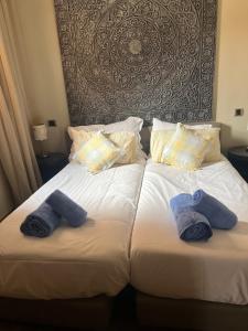 dwa łóżka w pokoju hotelowym z ręcznikami na nich w obiekcie Duplex Le Vizir for 6 with Park Access 3 Pools w mieście Dar Caïd Layadi
