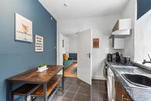 eine Küche mit blauen Wänden und einer Holzarbeitsplatte in der Unterkunft Regents House, Brighton in Brighton & Hove