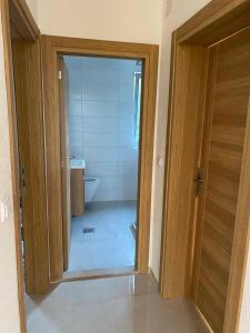 une porte ouverte menant à une salle de bains pourvue de toilettes. dans l'établissement Apartment in Tivat for rent, à Krasići 18 autres photos