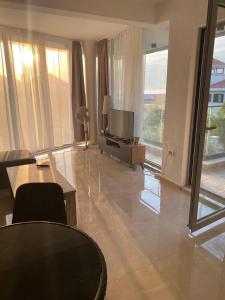 un salon avec une télévision, une table et des chaises dans l'établissement Apartment in Tivat for rent, à Krasići