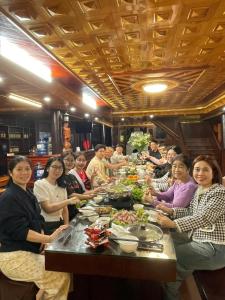 un gruppo di persone sedute a un tavolo che mangiano cibo di Sky Hill Sapa Retreat a Sa Pa Altre 43 foto