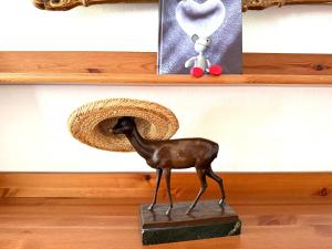 eine Statue eines Hirsches mit einem Strohhut auf einem Regal in der Unterkunft Stallteil in Oldsum + 17 Fotos