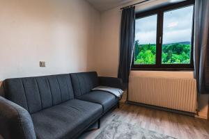 a living room with a couch and a large window at Zentral am Fluss #2 in Bad Ischl