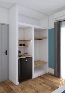 a kitchen with white walls and a black cabinet at Lᾶs Serifos in Livadi +12 photos