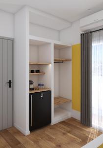 a kitchen with white walls and a black cabinet at Lᾶs Serifos in Livadi