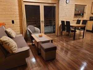 a living room with a couch and a table and chairs at Domki na Bukowinie in Węgierska Górka