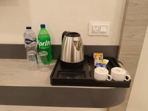 a counter with a coffee maker and two bottles of water at Veda INN by Chrysdorf in Faizābād