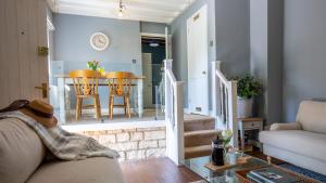 a living room with a couch and a table at Honeywick Cottage in Stow on the Wold +17 photos