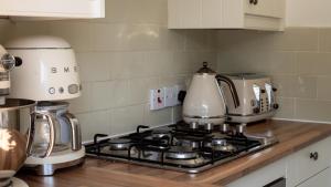 a kitchen counter with a stove top with a coffee maker at Honeywick Cottage in Stow on the Wold