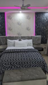 a bedroom with a bed with a black and white comforter at Nems Appartment in Ikeja