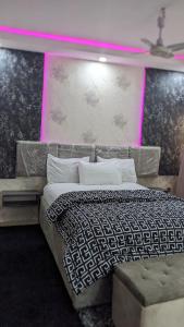 a bedroom with a large bed with pink lighting at Nems Appartment in Ikeja