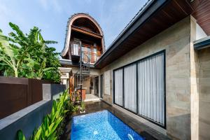 an external view of a house with a swimming pool at Yasana Jineng Villa 1 in Darmasaba
