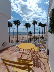 a yellow table and chairs on a balcony with the ocean at Cencibel - Harbor's Light in Villajoyosa
