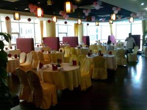 una sala da pranzo con tavoli bianchi e sedie gialle di Calvin Hotel a Canton