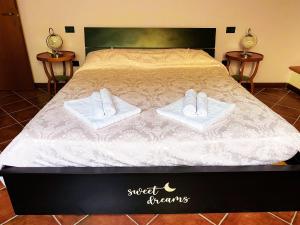 a bed with towels and slippers on top of it at Cascina Bruna villa con giardino in Val Trebbia in Bobbio +53 photos