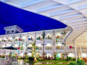 a large white building with palm trees in front of it at N Hotel in Cagayan de Oro
