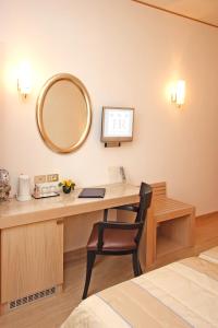 a room with a desk with a mirror and a chair at Hotel Roma in Trieste