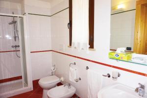 ein Badezimmer mit einem WC, einem Waschbecken und einem Spiegel in der Unterkunft Masseria Pappo in Copertino