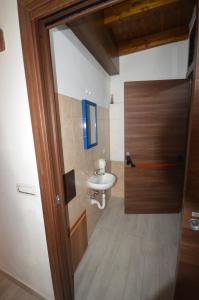 a bathroom with a sink and a wooden door at Gafo da Longa in Satriano