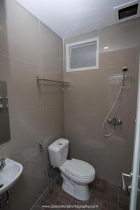 a bathroom with a toilet and a sink at Smart Budget Hotel in Semarang +60 photos