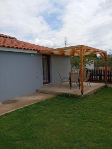 a wooden pergola with a table and chairs on a patio at Armonia House in Dhíkella