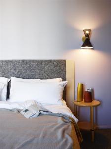 ein Schlafzimmer mit einem Bett mit einer Lampe und einem Tisch in der Unterkunft Alex Hotel in Perth