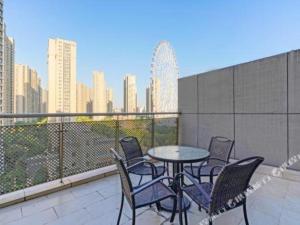 a table and chairs on a balcony with a city skyline at Nanjing Rsun Hotel in Taishan